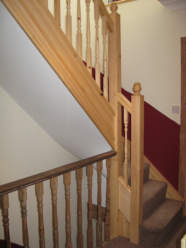 A softwood single turn winder staircase for a loft conversion, all left in natural pine with a clear varnished finish.