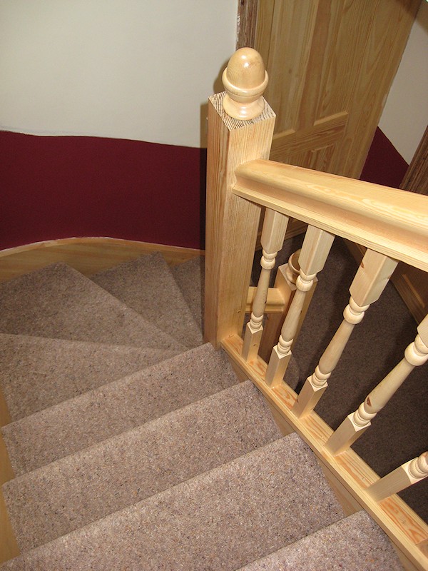 A softwood single turn winder staircase for a loft conversion, all left in natural pine with a clear varnished finish.