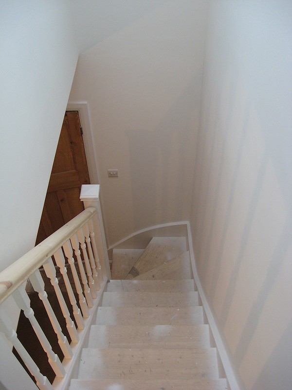A softwood staircase for a loft conversion, painted white with feature pine handrail.