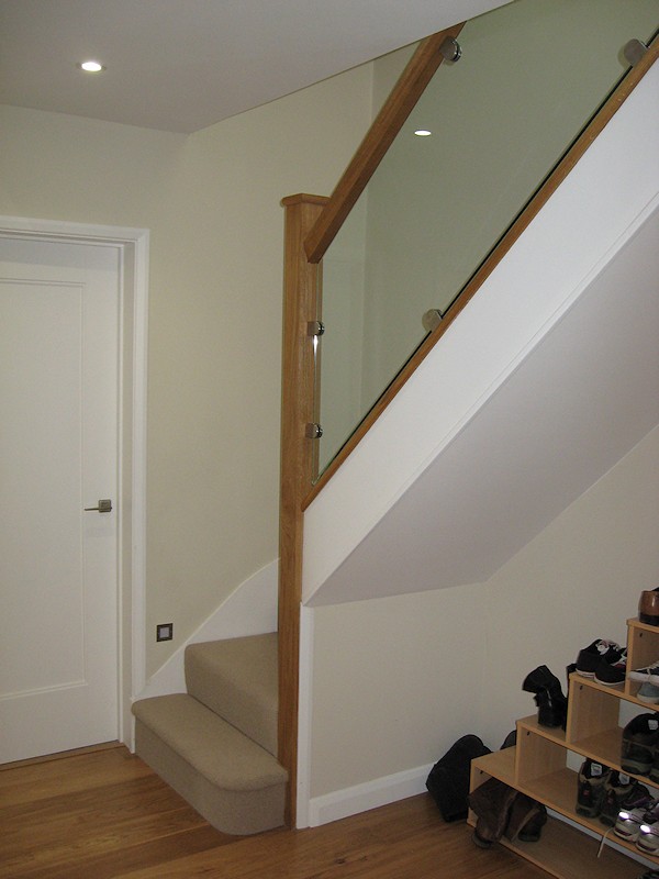This staircase has an ultra modern feel with glass balustrade and lighting mounted above the wall string.