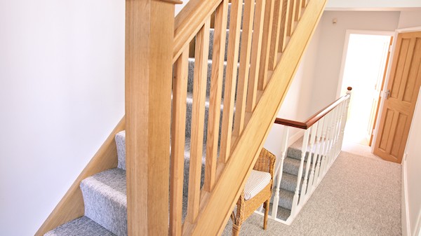 Oak staircase with our std profile handrail, square 32mm spindles and pyramid newel caps.
