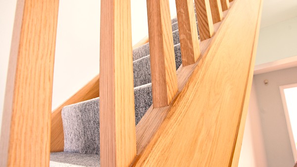 Oak staircase with our std profile handrail, square 32mm spindles and pyramid newel caps.