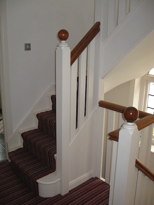 This softwood double winder staircase was for a loft conversion, painted white with a carpet runner.