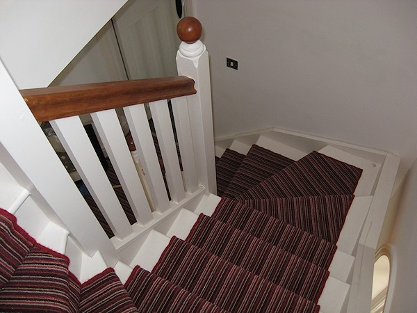 This softwood double winder staircase was for a loft conversion, painted white with a carpet runner.
